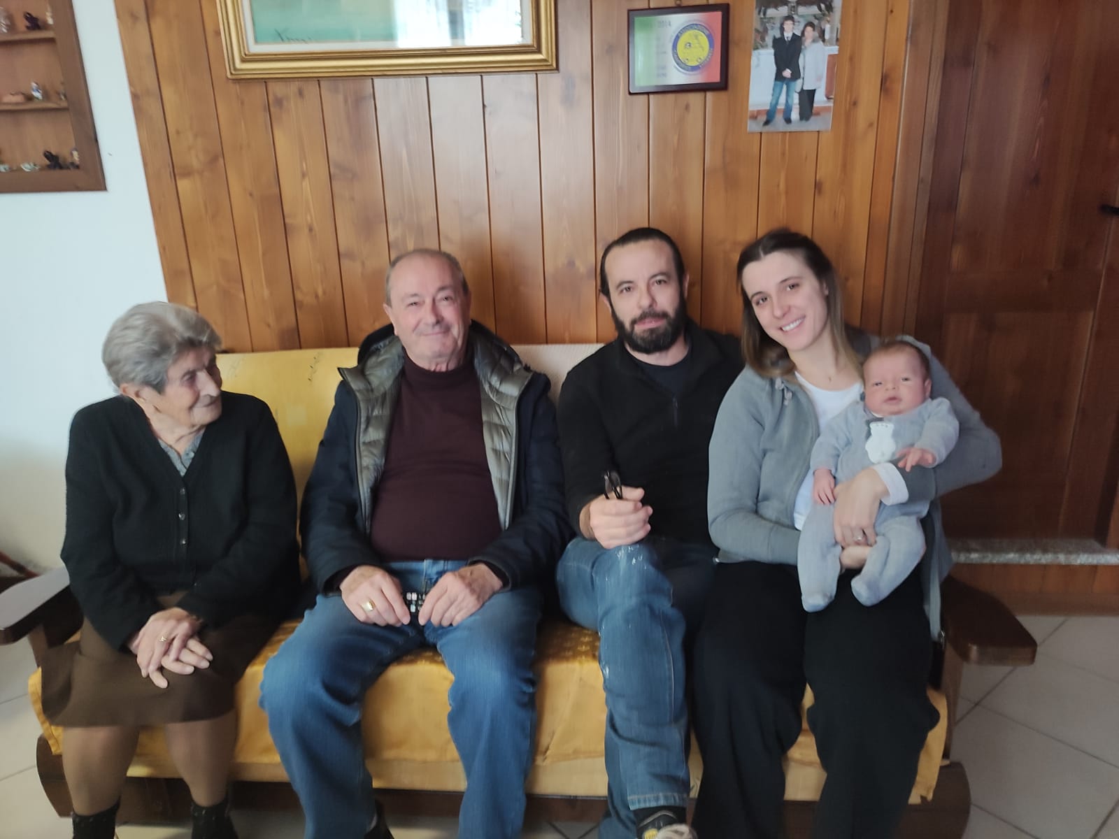 Cinque generazioni della famiglia Aramini sedute sul divano di casa a Villa San Giovanni in Tuscia